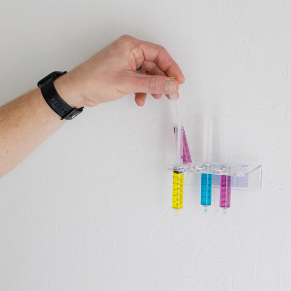 Syringe Caddy Medicine Storage mounted on wall with colorful syringes organized neatly.