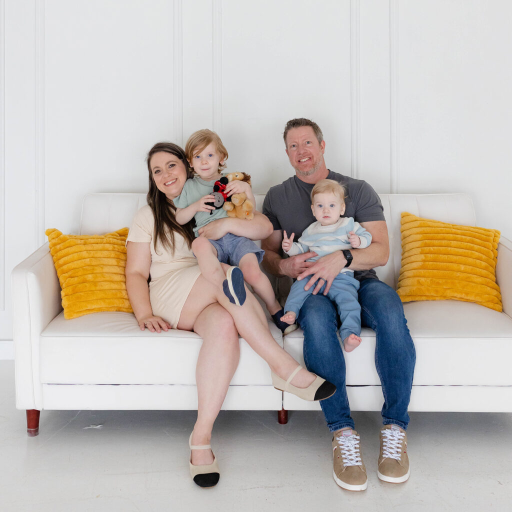 Sulo Storage Syringe founders family of four sitting together on white couch with yellow pillows